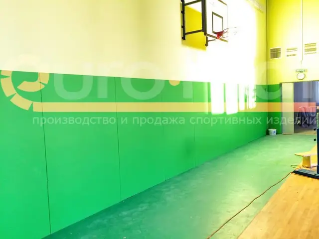 Зелёные стеновые протекторы вдоль баскетбольной площадки
