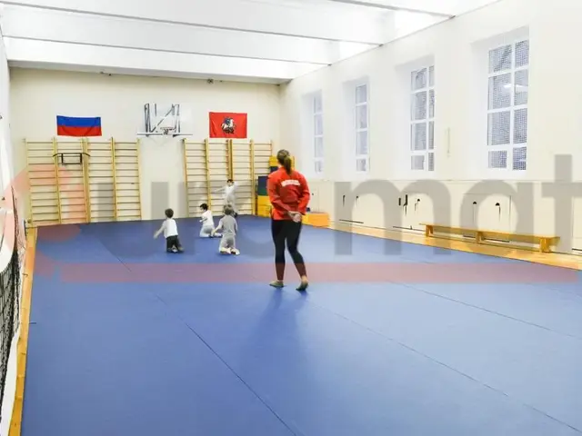 Тренировка на синем покрытии у гимнастических стенок