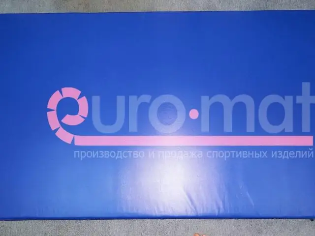 Синий прямоугольный гимнастический мат на сером полу