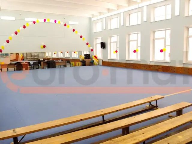 Серо-голубое покрытие и деревянные скамейки в зале