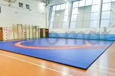 Борцовский ковёр сине-оранжевый в школьном зале со шведскими стенками