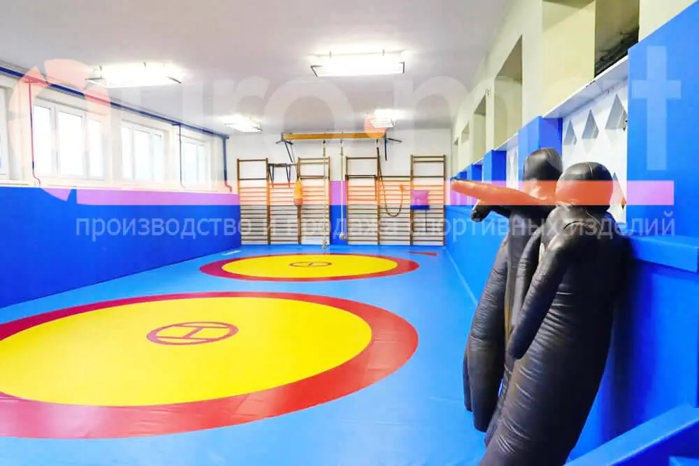 Борцовский ковёр жёлто-красно-синий в зале единоборств Грозного, манекены у стены
