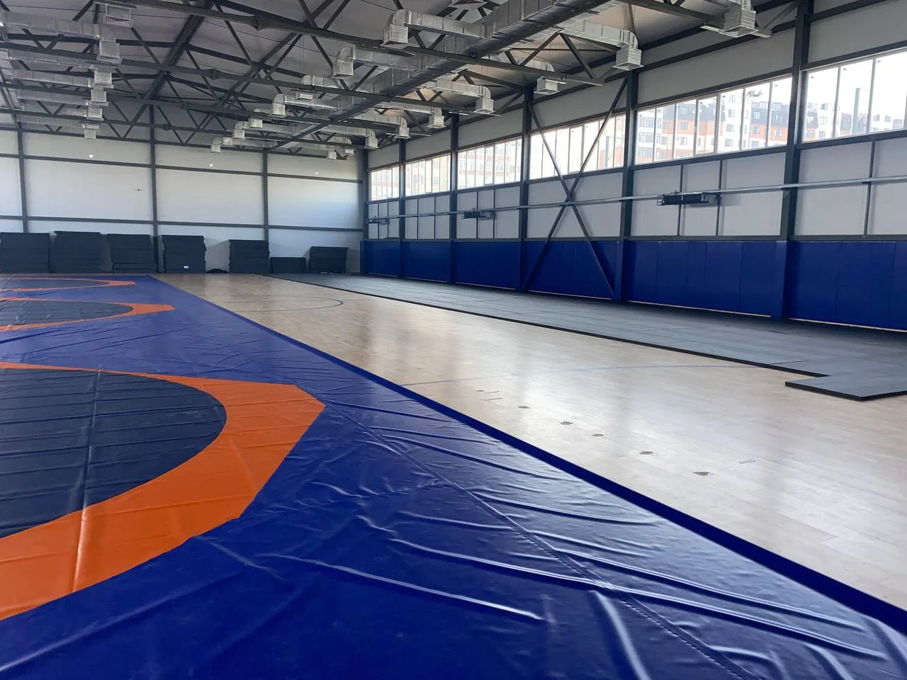 Панорамный вид полностью оснащённого зала борьбы с защитными протекторами