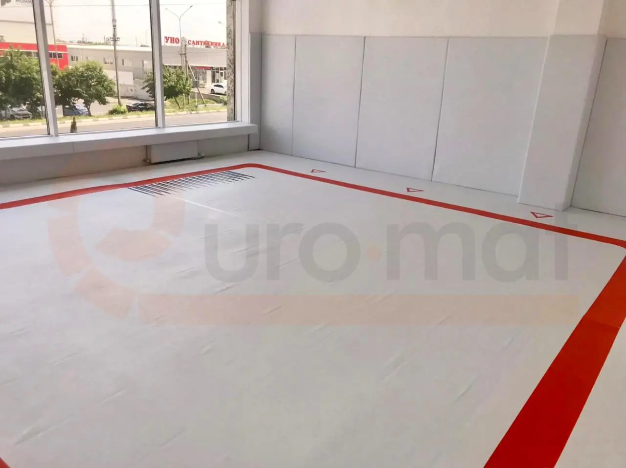 Белый борцовский ковёр с красной разметкой и белые стеновые протекторы в зале единоборств в Анапе