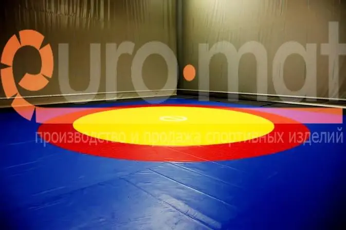 Борцовский ковёр крупным планом — жёлтый центр и красная зона борьбы