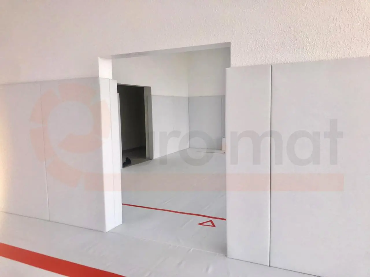 Стеновые протекторы серого цвета вокруг дверного проёма в борцовском зале Анапы с белым ковром