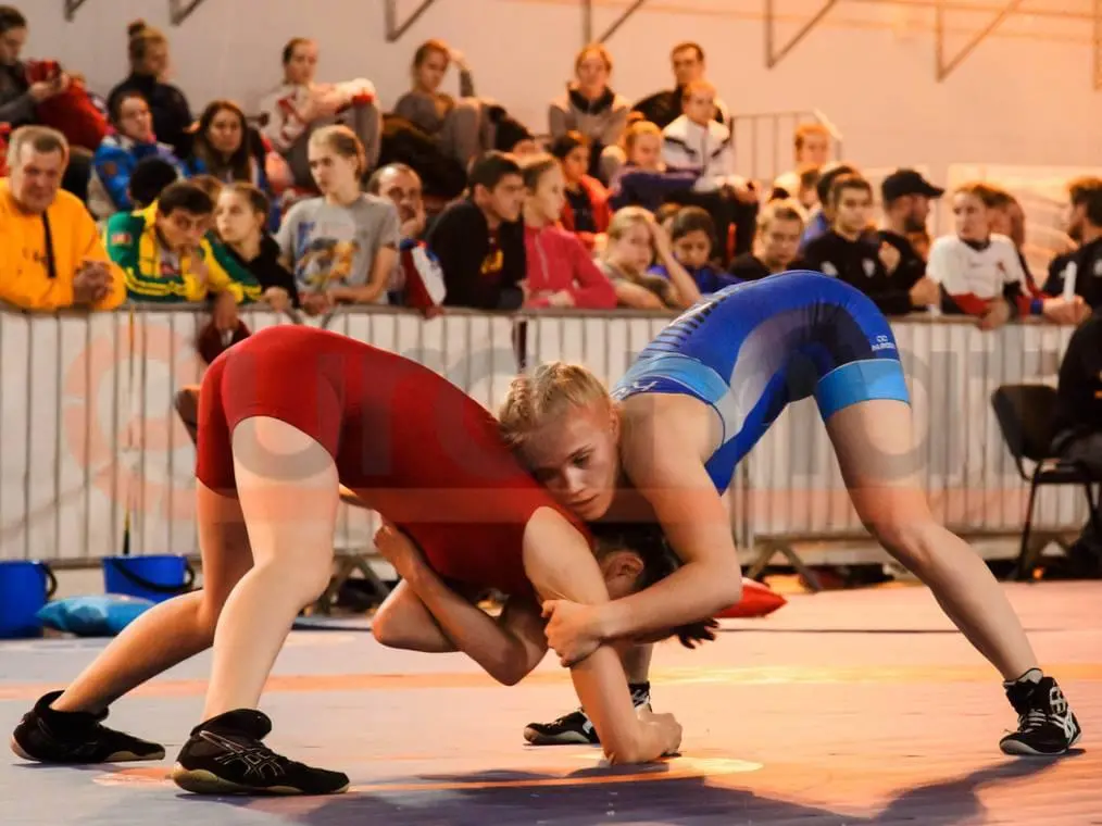 Женская борьба на синем борцовском ковре на соревнованиях в Санкт-Петербурге