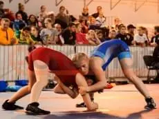 Женская борьба на синем борцовском ковре на соревнованиях в Санкт-Петербурге