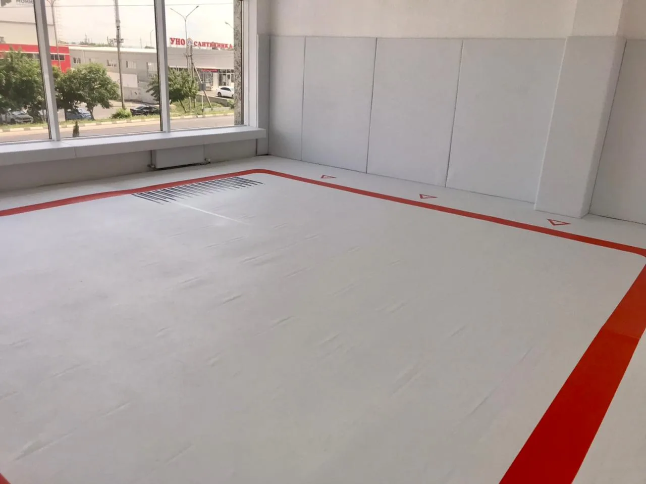 Белый борцовский ковёр с красной каймой и нестандартной разметкой, белые стеновые протекторы