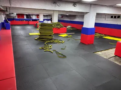 Широкий вид зала Витязь: черные будо-маты, трёхцветные протекторы и защитные чехлы на колоннах