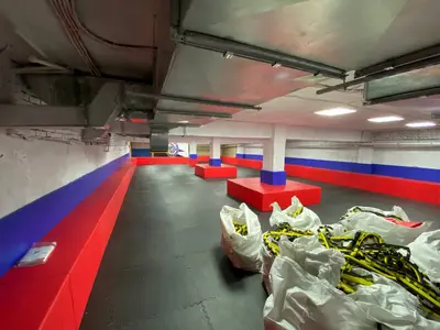Угол зала Витязь с красными и синими протекторами на стенах, черные будо-маты
