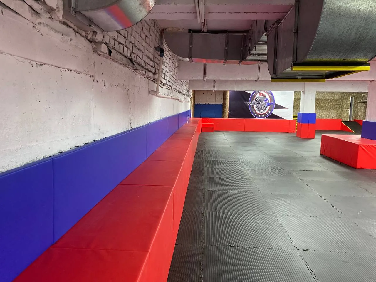 Установка красного индивидуального защитного чехла из ПВХ на круглую колонну в центре тренировочного зала