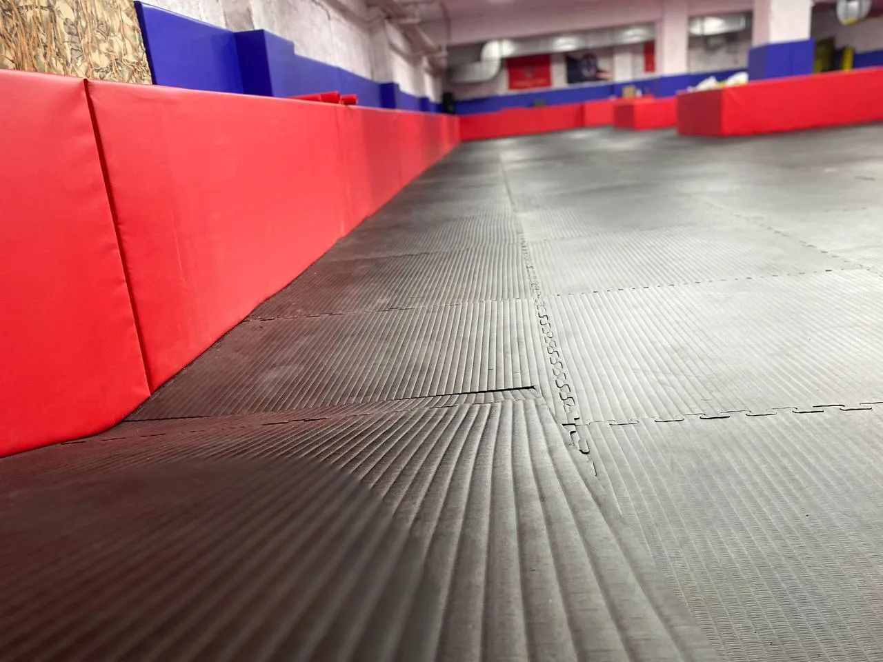 Спортсмены занимаются боевым искусством на уложенных чёрных будо-матах ЕВРОМАТ в готовом тренировочном зале