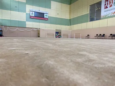 Бежевый ролл-гимнаст в спорткомплексе РЖД с баннерами и табло, вид с пола