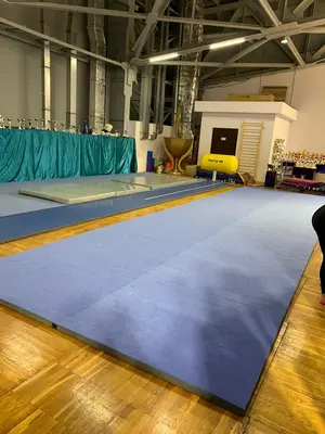 Голубой ковёр для гимнастики из двух дорожек в зале клуба чир спорта с кубками
