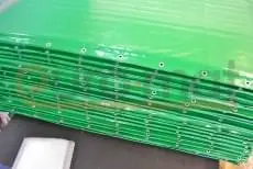 Стопка зелёных гимнастических матов с люверсами на производстве Евромат