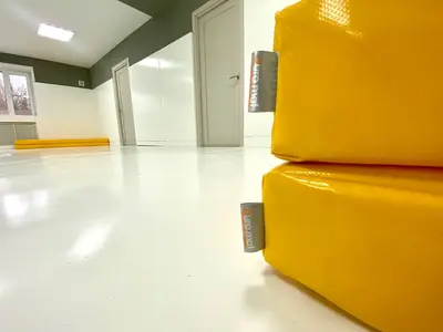 Два жёлтых гимнастических мата с логотипом Евромат на белом полу зала Император