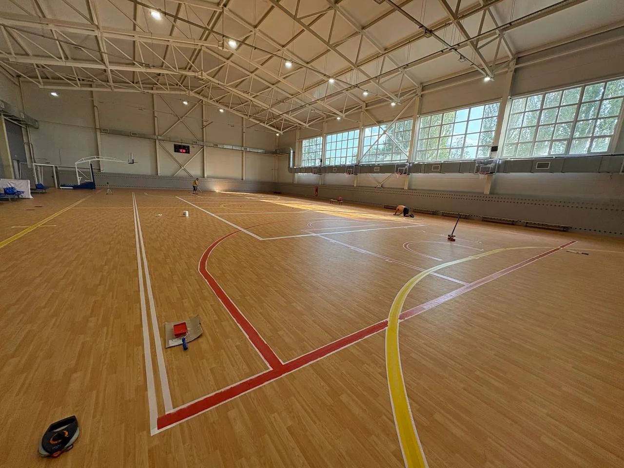 Нанесение красной и жёлтой разметки на деревянный паркет спортзала в Острогожске