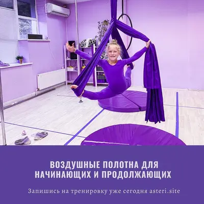 Девочка на воздушных полотнах над фиолетовым круглым матом для пилона в студии Астери