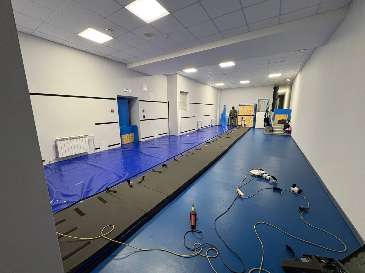 Сварка синего ролл-мата строительным феном в тренировочном зале АО «Атом-Охрана» с синими протекторами