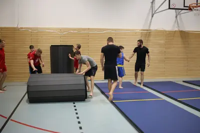 Тренировка ушу на синих ролл-матах с разметкой в спортзале Берлина