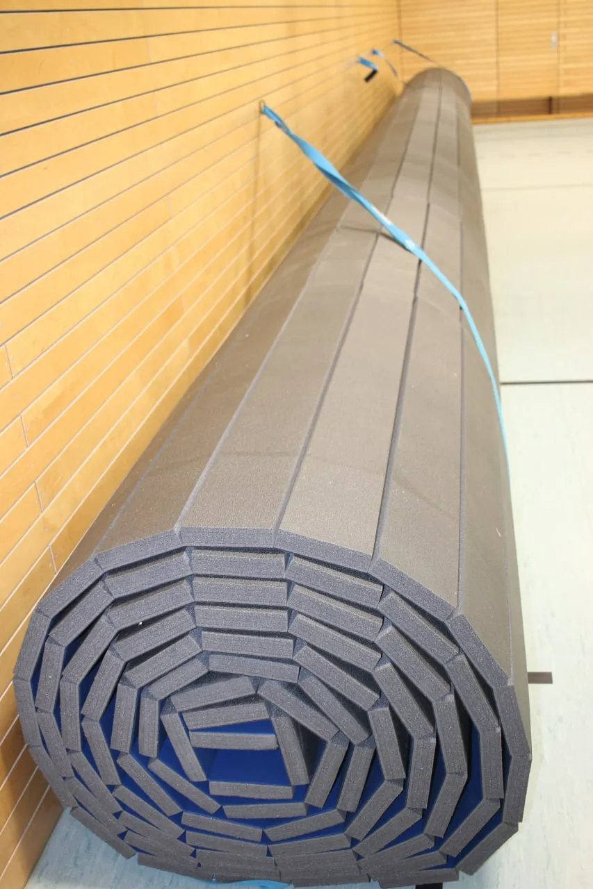 Развёрнутый ролл-мат синего цвета на месте установки в берлинском зале