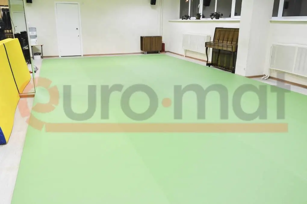 Светло-зелёный ролл-мат на полу зала единоборств с зеркалами и складным матом