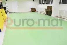 Светло-зелёный ролл-мат на полу зала единоборств с зеркалами и складным матом