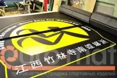 Крупный план логотипа Джук Лум с иероглифами на чёрном ролл-мате в цеху