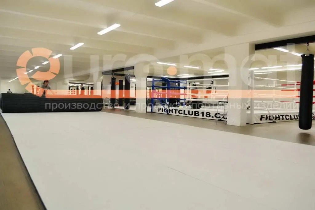 Белые ролл-маты на полу бойцовского клуба FightClub18 с рингом
