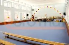 Светло-голубые ролл-маты в гимнастическом зале с аркой из шаров