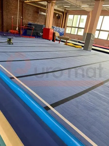 Ролл-маты серого цвета с разметкой в гимнастическом зале в Москве с брусьями и снарядами