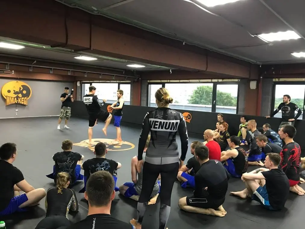 Чёрные ролл-маты с логотипом MMA Kegi в зале единоборств, тренировка бойцов