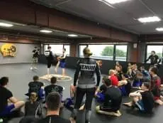 Чёрные ролл-маты с логотипом MMA Kegi в зале единоборств, тренировка бойцов