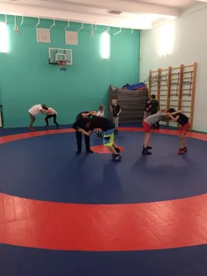 Тренировка юных борцов на синем ролл-мате с красной разметкой в спортшколе "Корела"