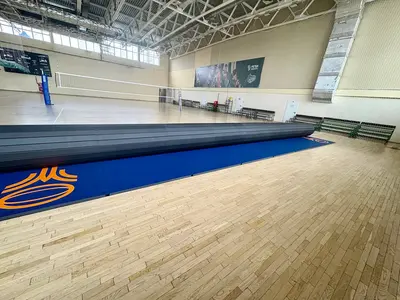 Синий ролл-мат с оранжевым логотипом регби раскатывается в арене Академии регби Зеленограда