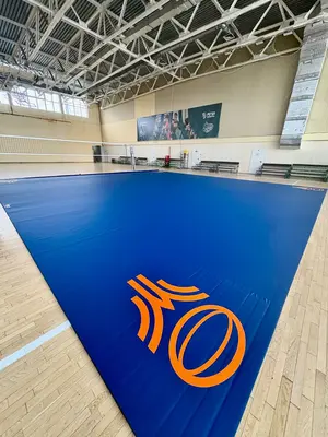 Синий ролл-мат полностью уложен в арене с большим оранжевым логотипом регбийного клуба