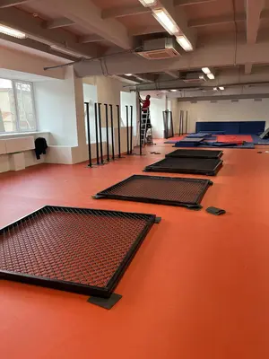 Красный ролл-мат и сетка ММА в зале РТУ МИРЭА в Москве во время монтажа