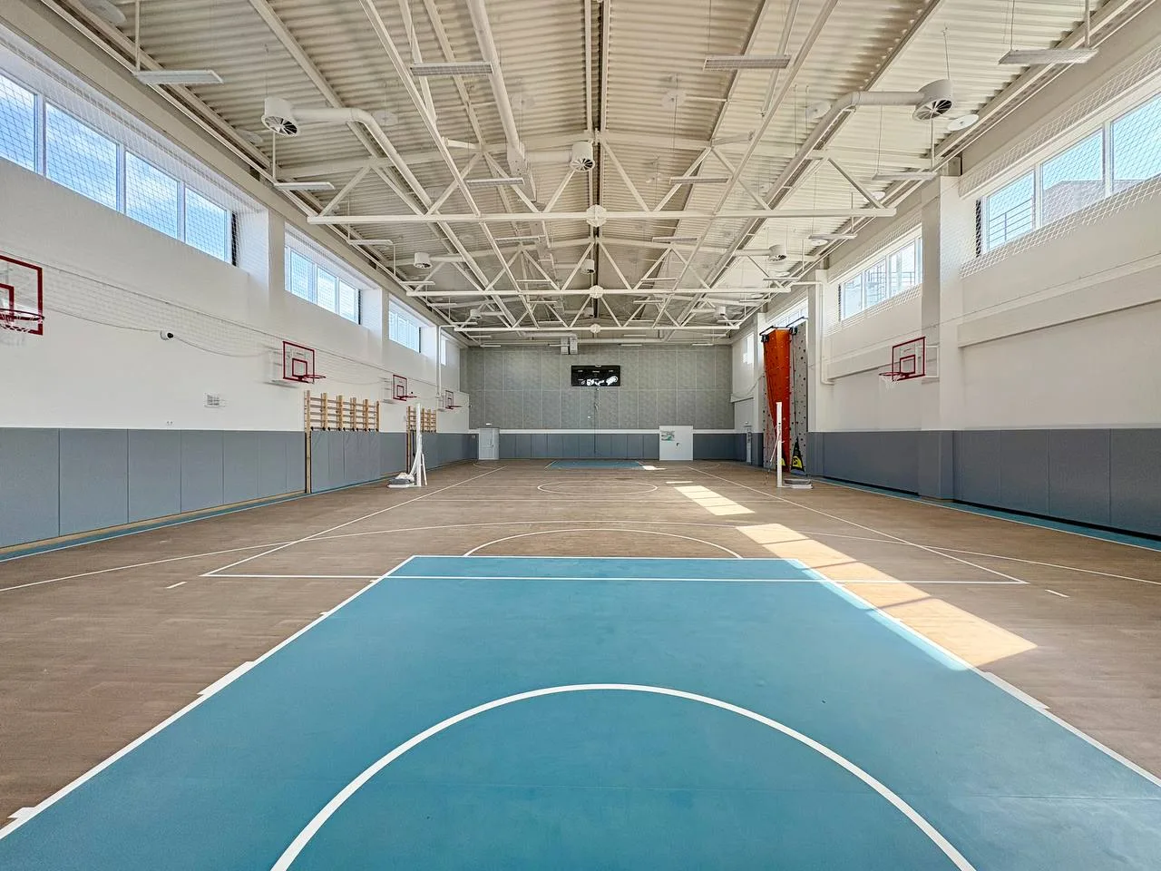 Серо-голубые стеновые протекторы в большом спортзале школы п. Северный с баскетбольными щитами