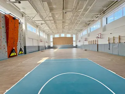 Спортзал школы Северный с серыми протекторами, оранжевым скалодромом и голубой площадкой