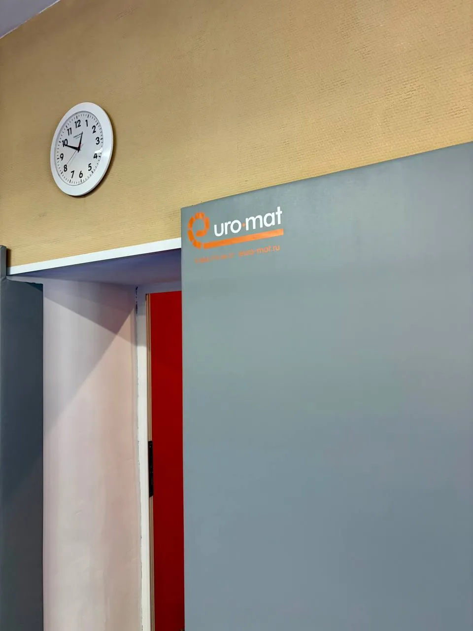 Стеновой серый протектор с логотипом Евромат у дверного проема зала борьбы в Красный Электрик