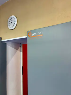 Серый стеновой протектор с логотипом Евромат у дверного проёма в зале борьбы