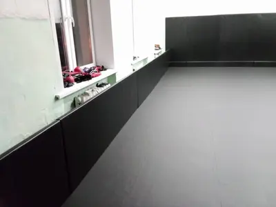 Черные протекторы на стенах и ролл-мат на полу в тренировочном зале, турник на стене