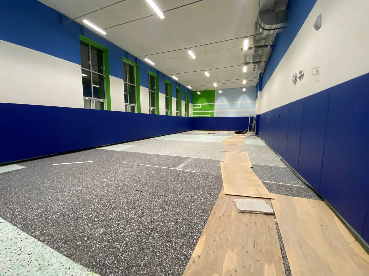 Синие стеновые протекторы по периметру зала центра Созвездие в Архангельске, укладка пола