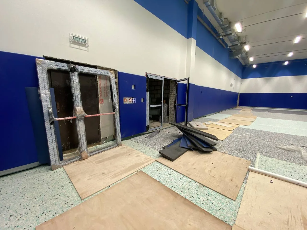 Аккуратный стык двух синих стеновых протекторов в углу спортзала под 90 градусов