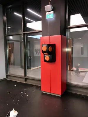 Красный протектор на колонне с тренажёром для ударов и силуэтами боксёров на стенах