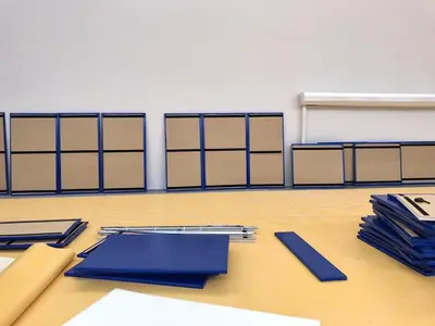 Синие стеновые протекторы из ПВХ сложены стопкой у стены — видна тыльная сторона с полосами велькро