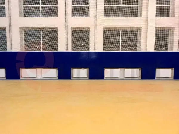 Тёмно-синие стеновые протекторы с вырезами под батареи в зале единоборств, фронтальный вид