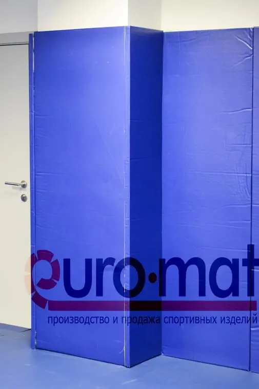 Синие стеновые протекторы крупным планом у двери в клубе FIT'N'FIGHT