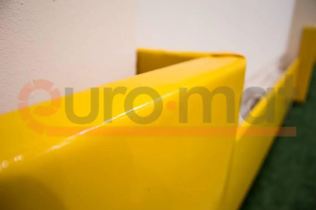 Жёлтые стеновые протекторы крупным планом в углу спортзала гимназии